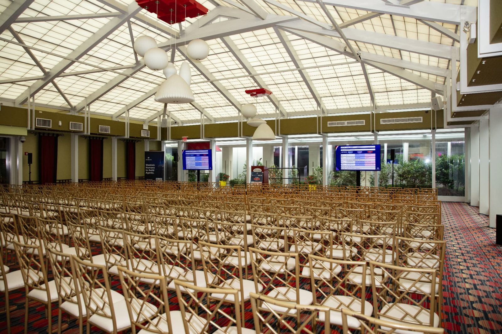 The main hall at The Practical AI Conference, set with rows of seating under a skylight